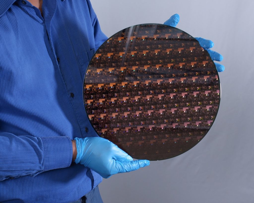 A picture of a semiconductor technician holding a wafer of the newest innovation in transistors, IBM's 2nm.