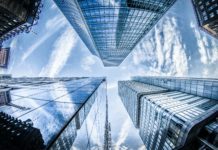 A picture taken from street level looking up at skyscrapers in a city. In this case, the buildings represent the reality that on-premises infrastructure is here to stay while data centers realize the public cloud isn't everything propaganda sold it as.